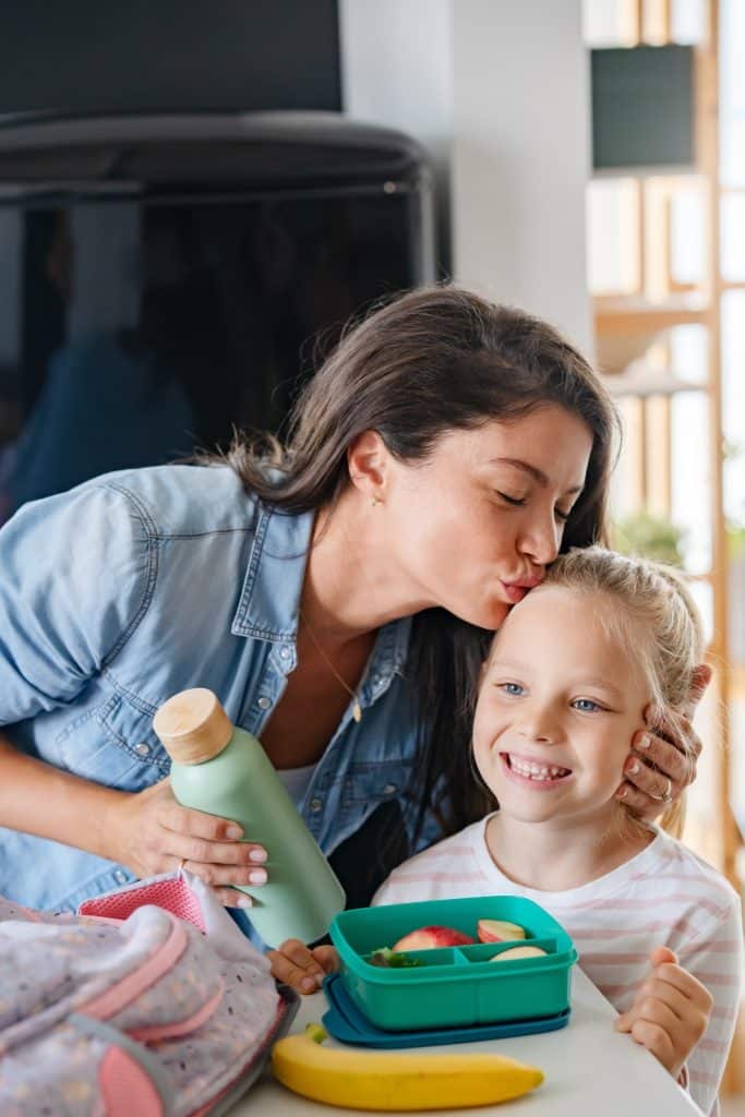 mom packing lunchbox with fruit and stuffed dates snack