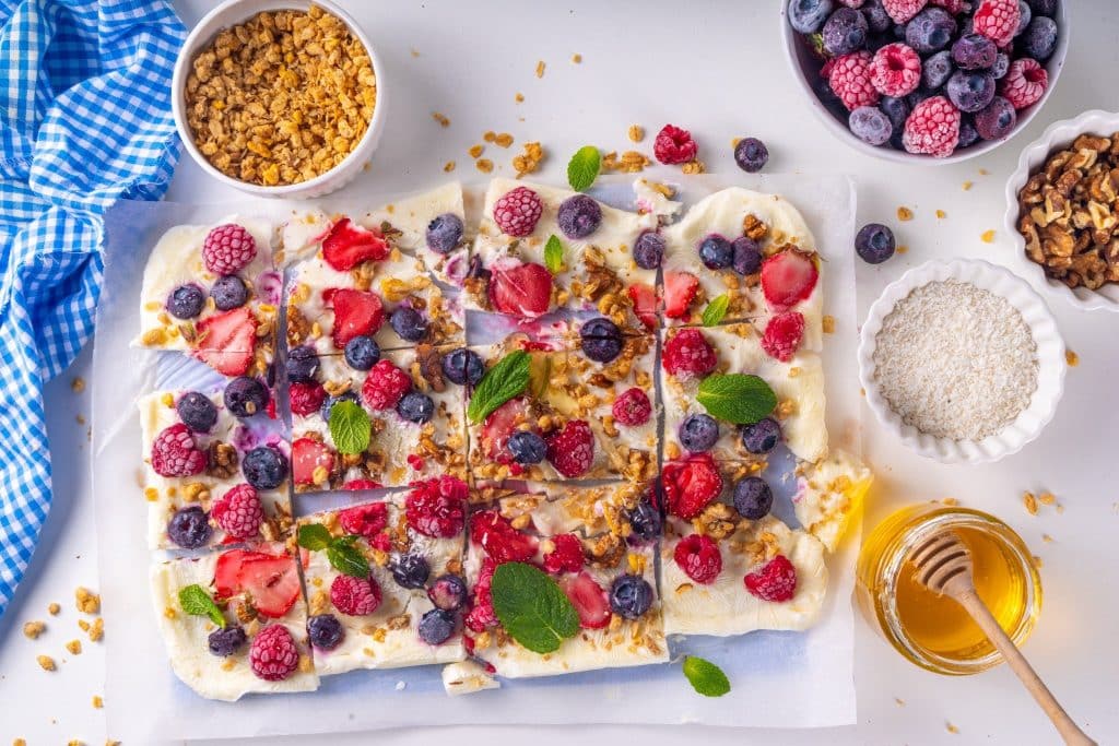 Greek yogurt bark topped with fresh berries and granola flat lay