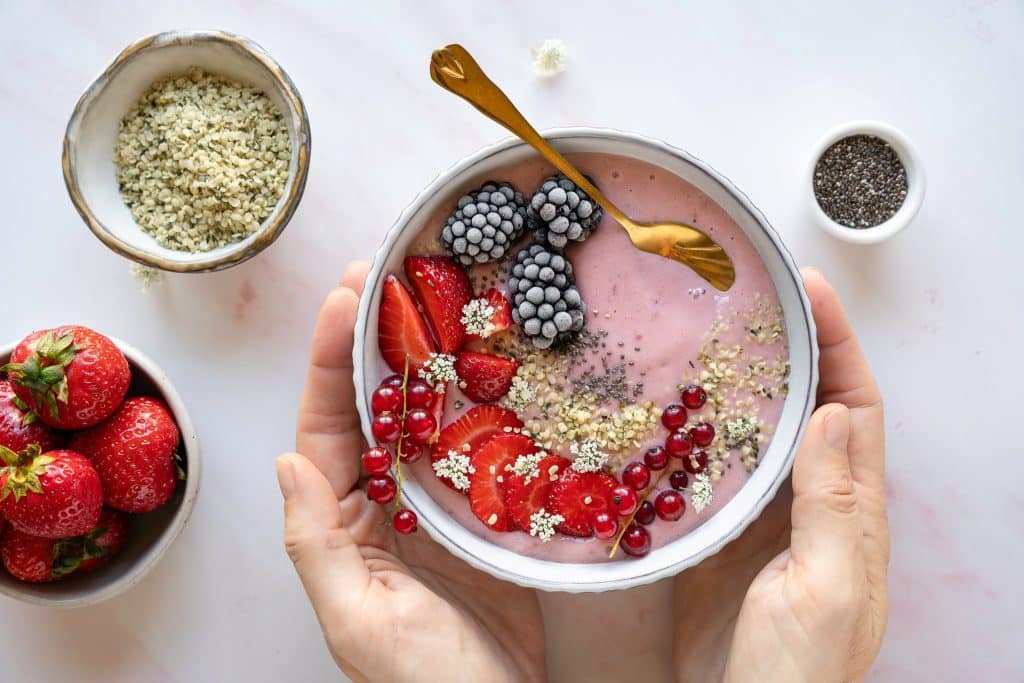 Pink smoothie bowl with berries and hemp seeds on top