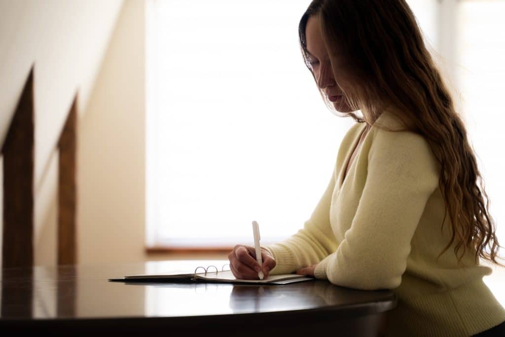 Woman journaling food and mood at a desk