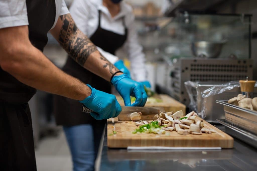 Chef slicing mushrooms on a cutting board