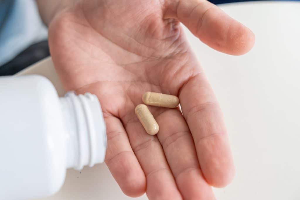 hand holding probiotic supplement capsules with psychobiotics for anxiety