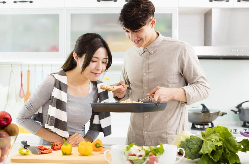 Couple cooking dinner and tasting rice