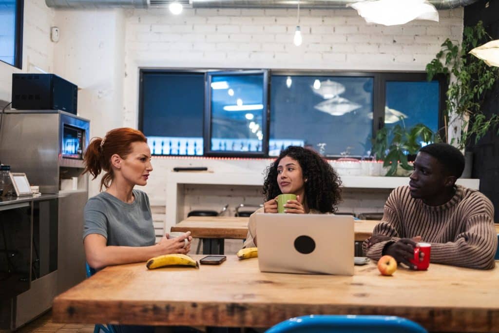 Coworkers in breakroom with coffee and simple snacks for work