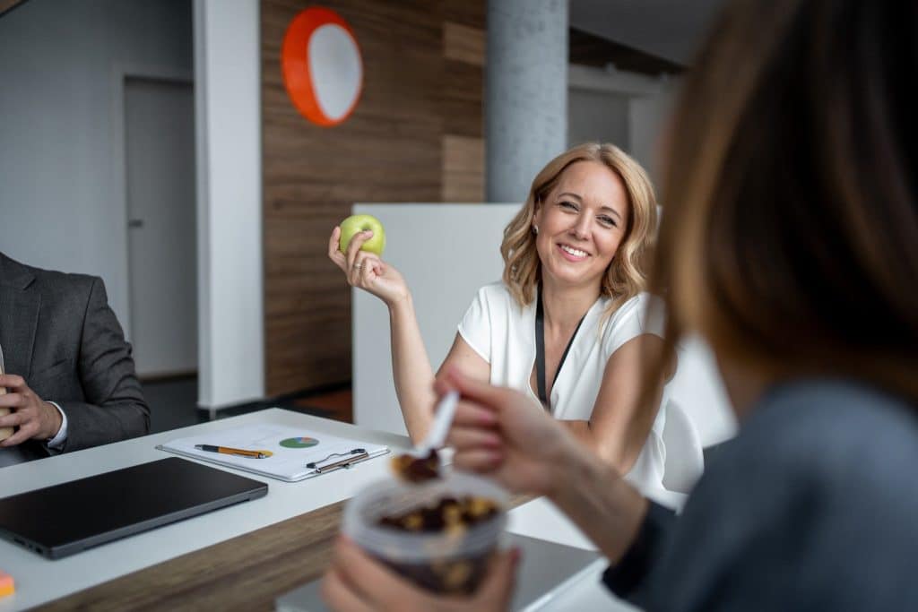 Office worker smiling with apple showing simple snacks for work