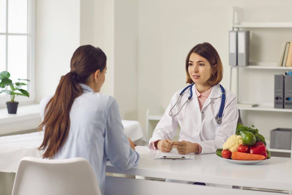 Nutritionist discussing healthy eating with patient, recommending the benefits of ancient grains like quinoa, amaranth, and millet.