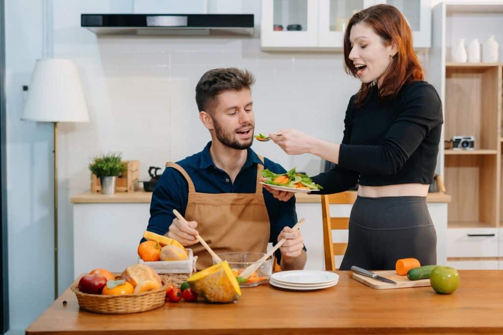 Couple cooking vegetables and sharing a healthy meal at home, representing the positive impact of a diet for anxiety and depression.