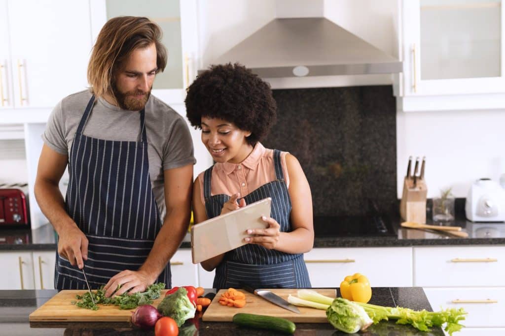 Couple cooking fresh vegetables together at home during the food choices pandemic, reflecting the shift to home kitchens and new meal habits.