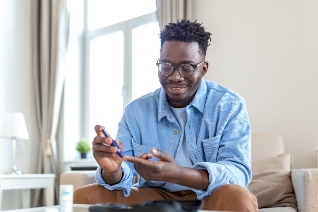 man checking blood sugar at home