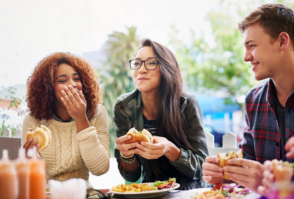 Friends enjoying burgers at an outdoor table