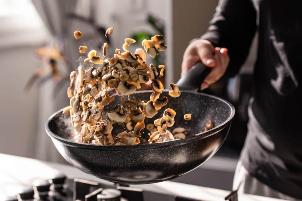Sautéing chopped mushrooms in a hot pan