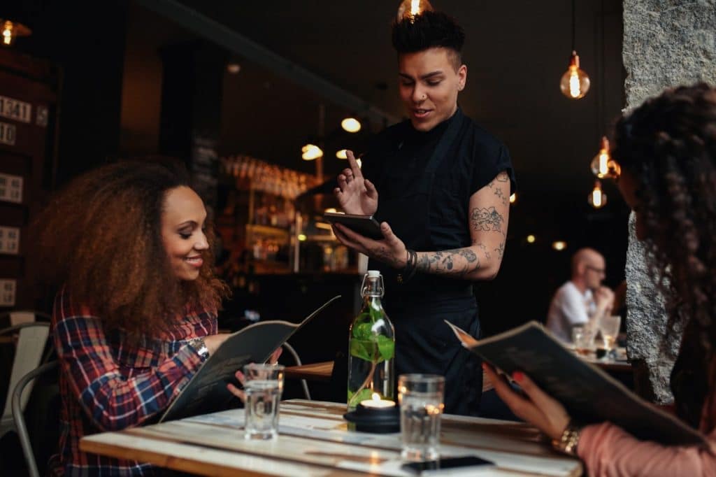 erver explains carbon footprint labels on food to diners