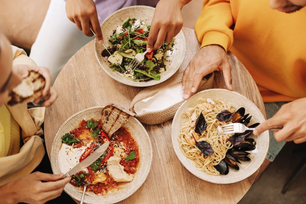 Friends enjoying balanced dishes together illustrating the food and mental health connection through social meals.