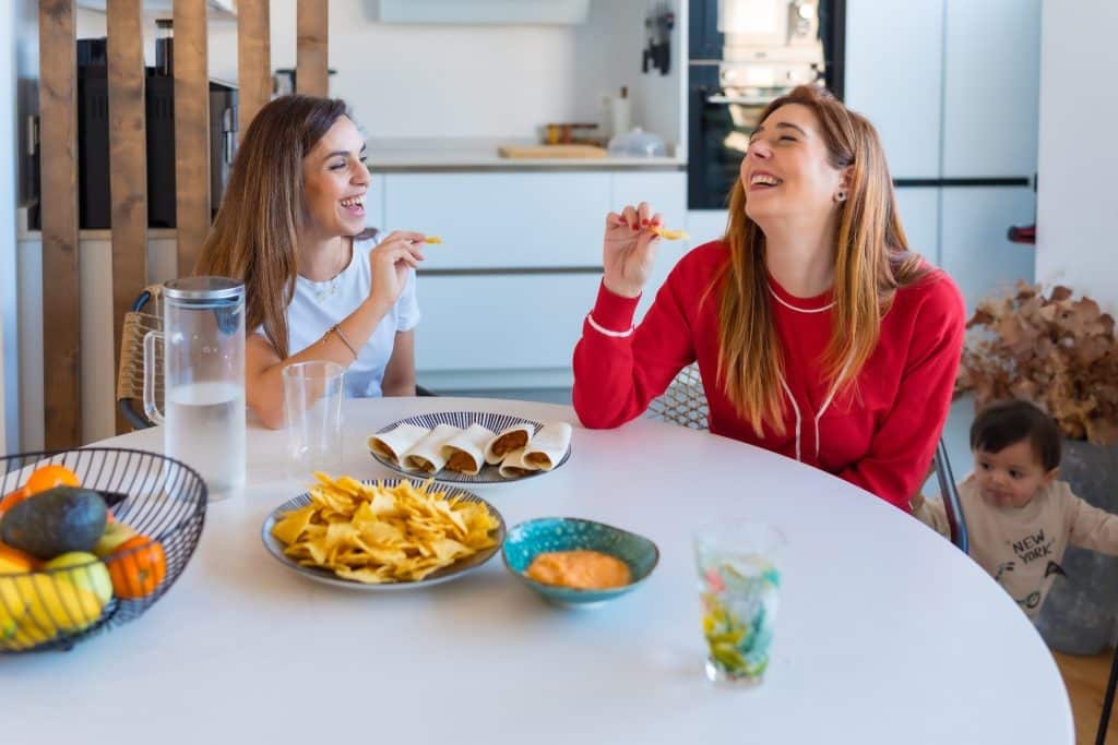 Friends sharing okara chips at a kitchen table