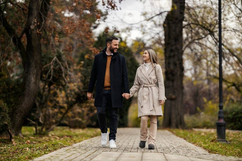 Couple taking a relaxed after-lunch walk to support an improve digestion diet.