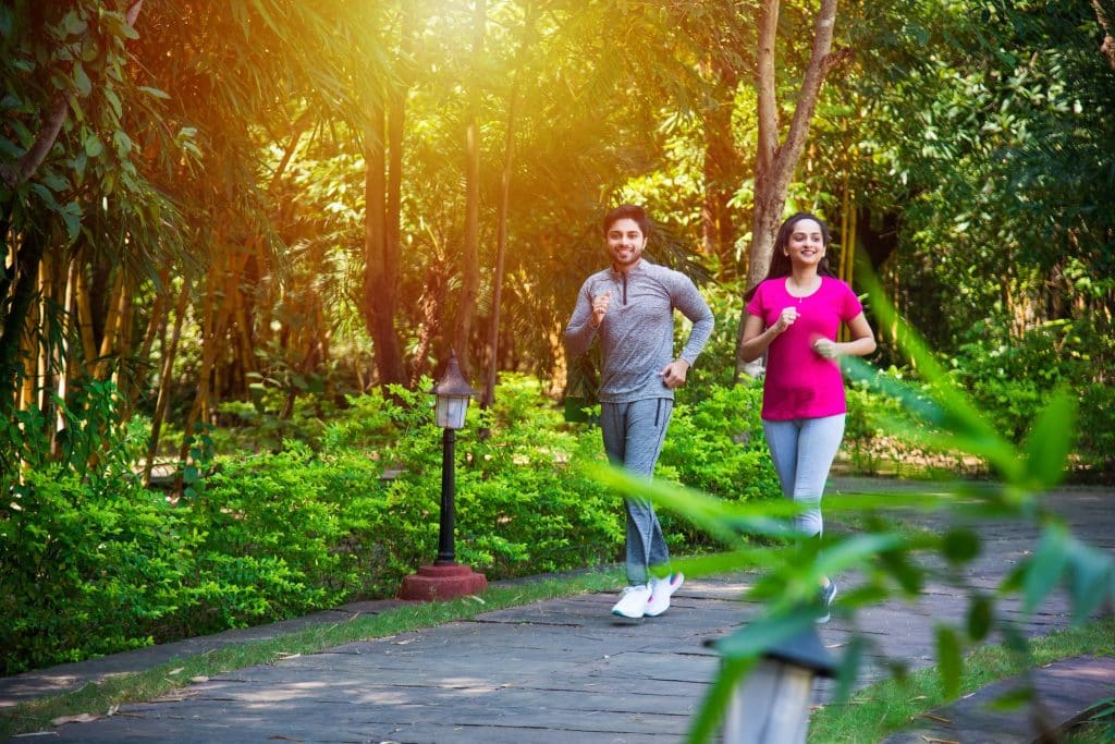 Couple jogging in a sunny park; maca root benefits for endurance