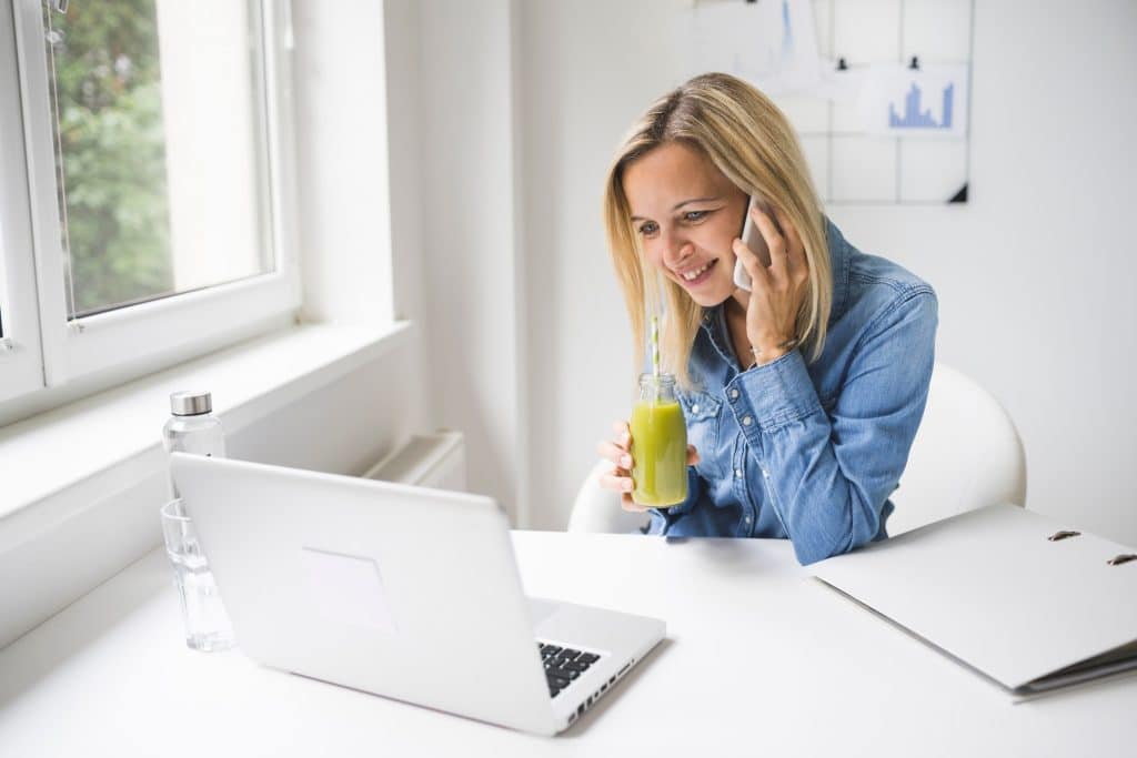 Professional sipping a green smoothie while working