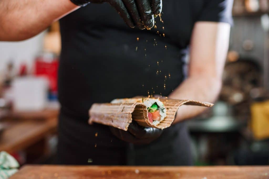 Chef preparing plant based seafood sushi roll