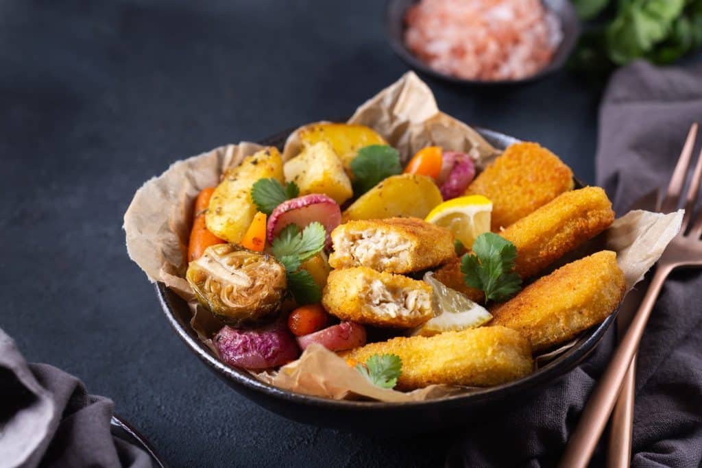 Bowl of crispy plant based seafood with roasted vegetables