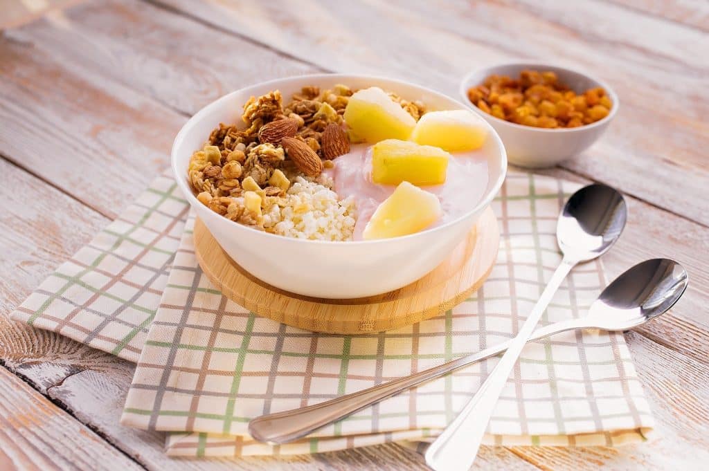 Yogurt bowl with pineapple granola and almonds for tryptophan foods mood