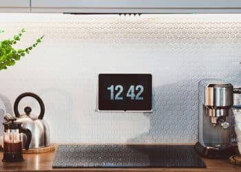 a kitchen counter with a clock and a potted plant