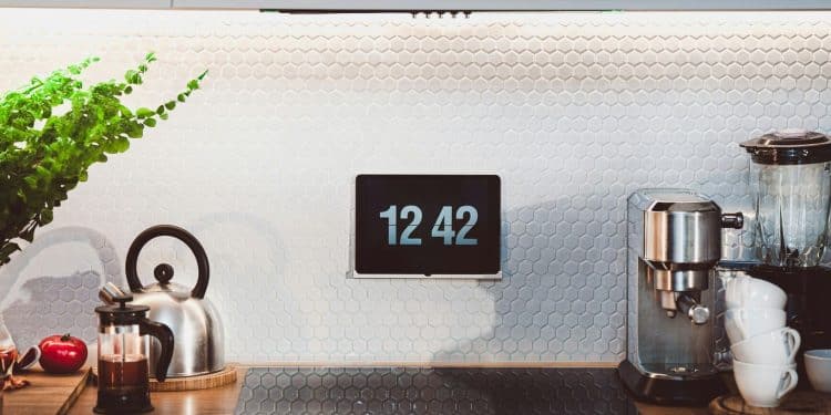 a kitchen counter with a clock and a potted plant